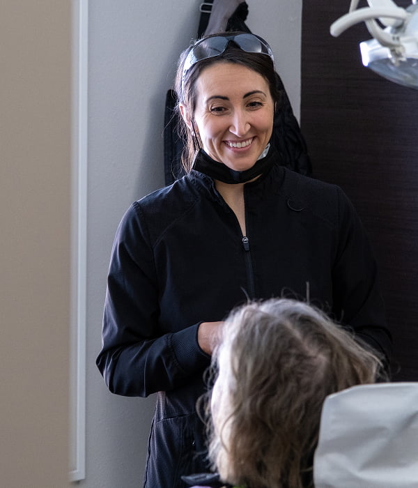 One of our dentists at Burgmeier Dentistry speaking with a woman seated in the dental chair at our Mason City office