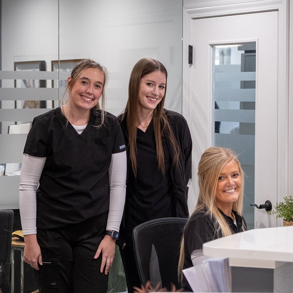 Three of our dental assistants at Burgmeier Dentistry smiling in the dental office