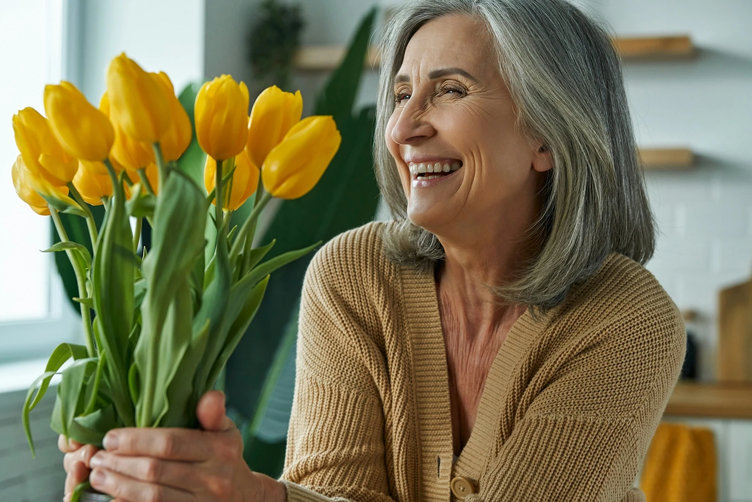A woman sits looking at flowers